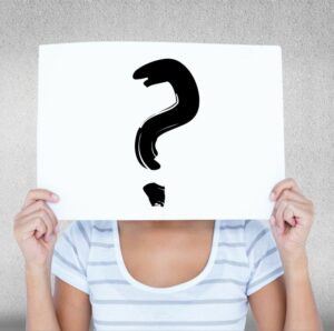 Woman holding question mark sign before her face